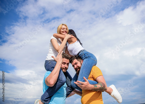 Couples on double date. Inviting another couple to join. Friendship of families. Twice fun on double date. Couples in love having fun. Men carry girlfriends on shoulders. Summer vacation and fun