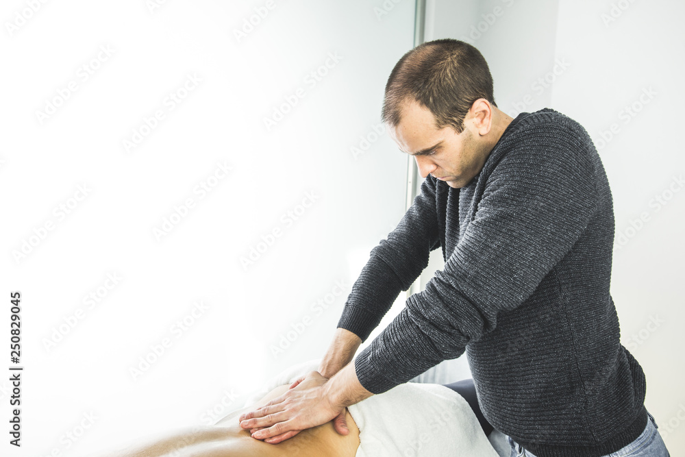 Physiotherapist working doing a massage on a patient back. Concept of physiotherapy and wellness Physiotherapist working doing a massage on a patient back. Concept of physiotherapy and wellness