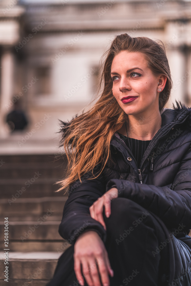 fashionable portrait of young beautiful woman in a European city on a sunny winter day