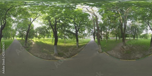 360 VR video. Park with green trees and lawns near the road in Moscow, Russia. Asphalt and well trodden paths running through it photo