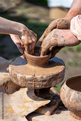 people make a ceramic pot on the potter's wheel