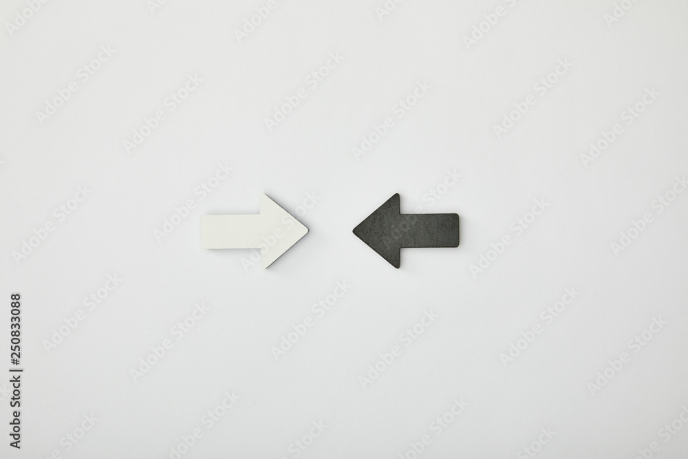 top view of white arrow opposite black pointer on grey background top view of white arrow opposite black pointer on grey background