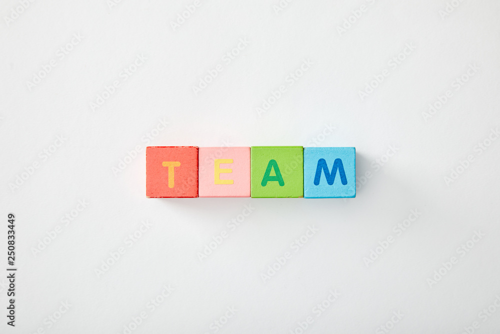 top view of team lettering made of multicolored cubes on grey background top view of team lettering made of multicolored cubes on grey background