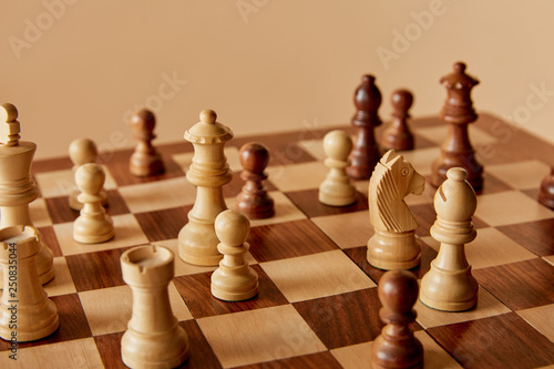 selective focus of chess on chess board and beige background