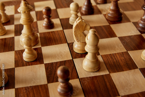 chess pieces on wooden brown chess board