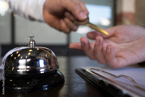 Close up of hand guest takes room key at check-in desk of the hotel.Hotel concept.