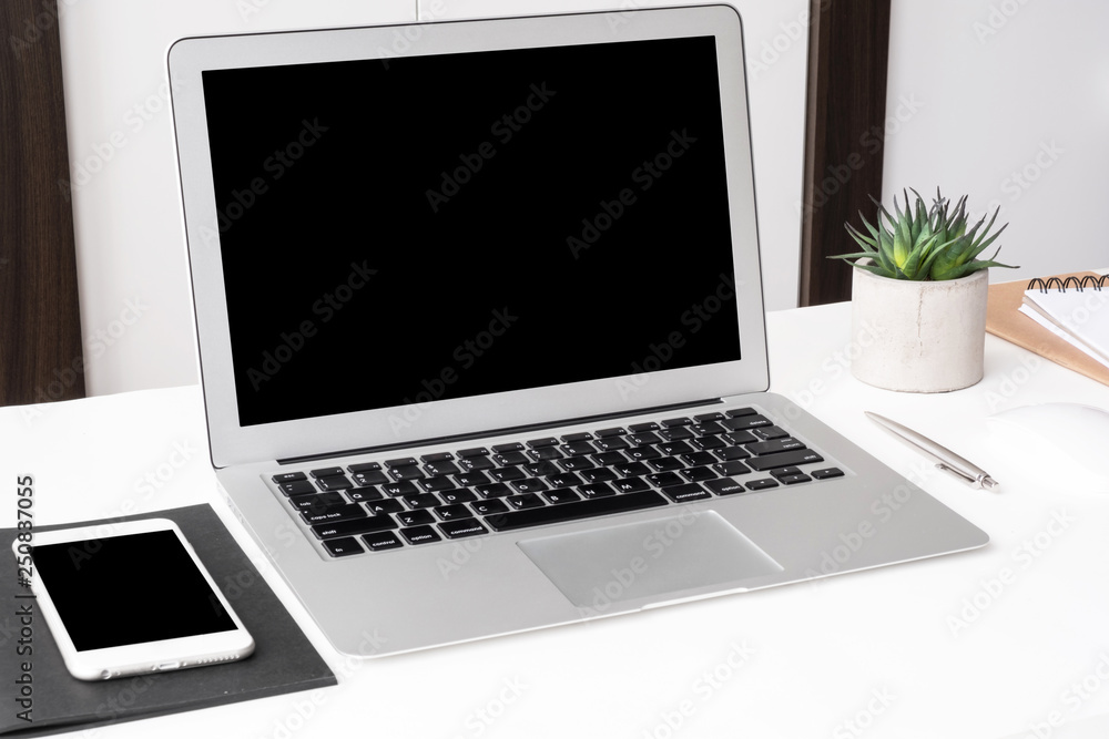 Laptop computer and smartphone with blank mock up screens are on top of white office desk table. Laptop computer and smartphone with blank mock up screens are on top of white office desk table.