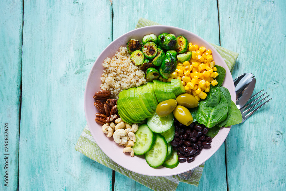 budha bowl with brussel cabbage, corn, quinoa, cucumbers,nuts, avocado and spinach