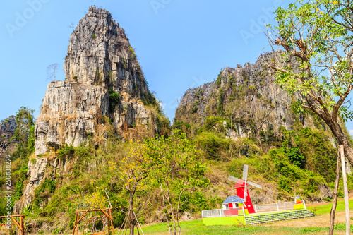 Landscape view of farmer hut in the rice field after harvested with limestone mountains range and blue sky background at Ban Mung village, Noen Maprang district, Phitsanulok province, Thailand. photo