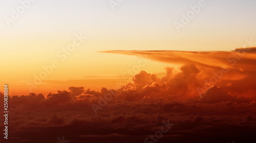  footage of beautiful sunset clouds from airplane window. Bright intense orange cloudscape view from above. Flight through moving yellow clouds in the evening sunshine.