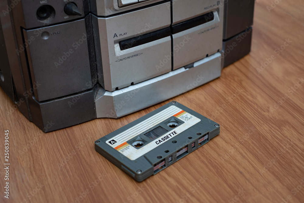 Fototapeta premium Vintage compact cassette and audio tape player on table wood background