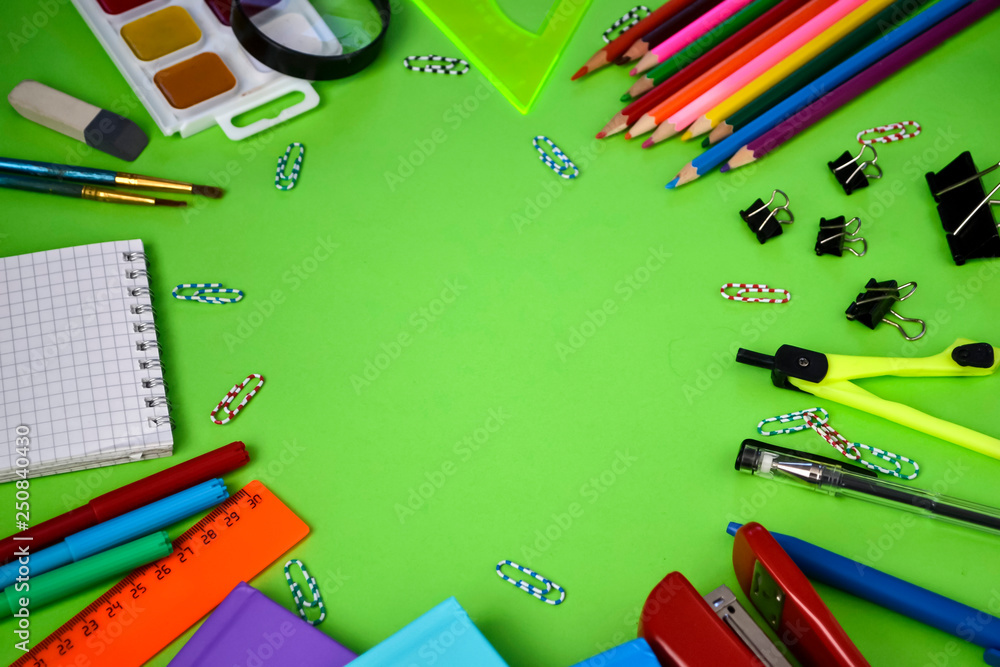 school subjects: pens, notebooks, pencils, paper clips on a light green background school subjects: pens, notebooks, pencils, paper clips on a light green background