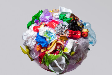 A globe of the earth with trash over white background, the concept of ecology problem and World Environment Day. Photo with message for social advertising, place for inscription