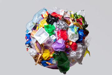 A globe of the earth with trash over white background, the concept of ecology problem and World Environment Day. Photo with message for social advertising, place for inscription