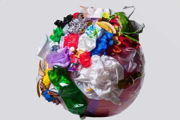 A globe of the earth with trash over white background, the concept of ecology problem and World Environment Day. Photo with message for social advertising, place for inscription