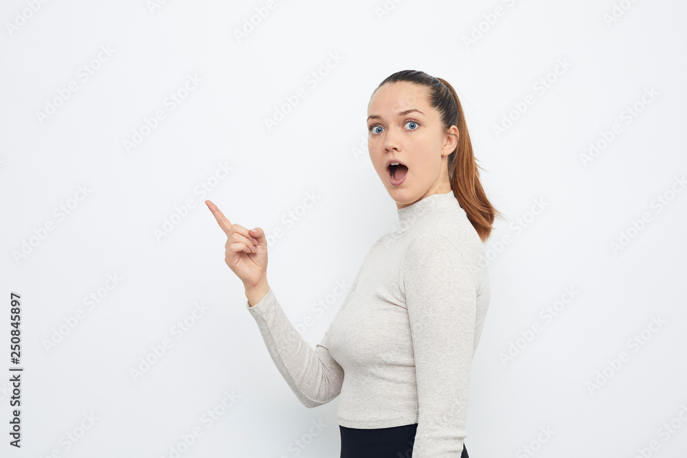 young brunette pointing at product copy space young brunette pointing at product copy space