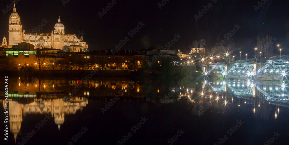 View of the cathedral of Salamanca reflected in the river at night, spain