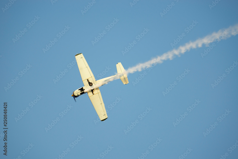 Airplane with Smoke Against Blue Sky in Switzerland. Airplane with Smoke Against Blue Sky in Switzerland.