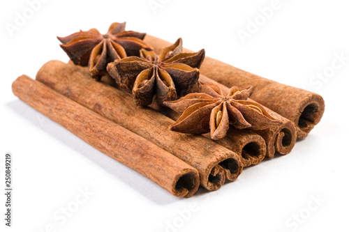 anise stars laying on cinnamon sticks isolated on white background.