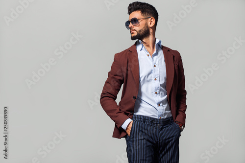 Elegant young handsome man in suite wearing glasses. Studio fashion portrait. photo