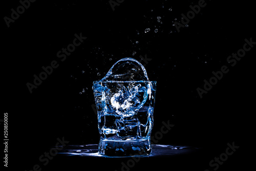 Splash ice cube in the glass of water or drink. Light, refreshment.