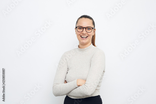portrait of young girl with arms crossed laughing on white background © Martin Villadsen