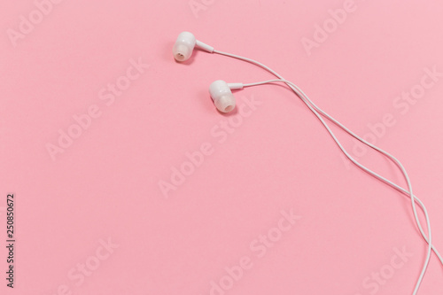 Headphones on pastel background. White headphones on a pink background.