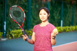 outdoor portrait of young female asian tennis player