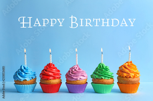 Canvas Print Delicious birthday cupcakes with candles on color background