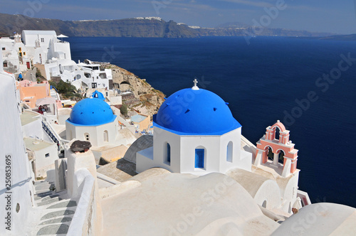 Greek white churchs with blue domes overlooking the sea, Oia, Santorini, Cyclades Islands, Greece.