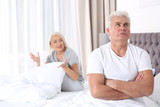Mature couple having conflict in bedroom at home. Relationship problems