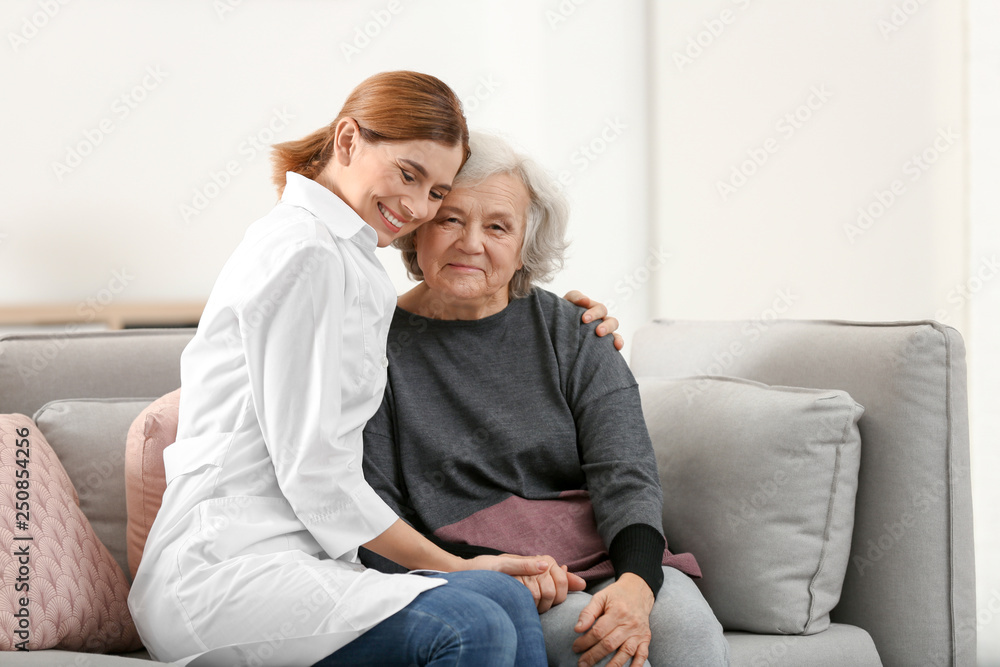 Elderly woman with female caregiver in living room