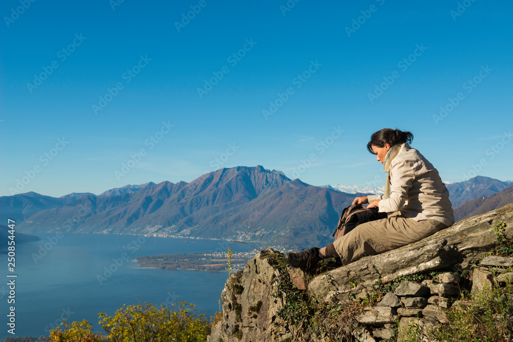 Woman Relax on a Mountain Top with Alpine Lake Maggiore in Background in Ticino, Switzerland.