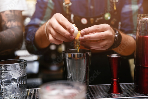 Bartender preparing tasty cocktail at counter in nightclub  closeup