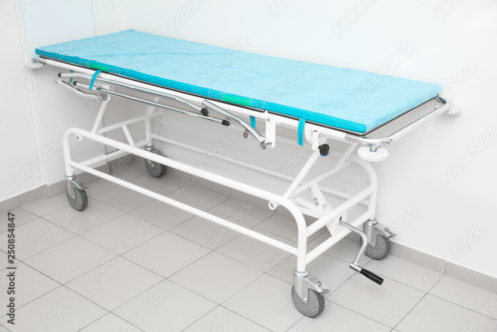 Medical trolley bed near wall in modern clinic Medical trolley bed near wall in modern clinic