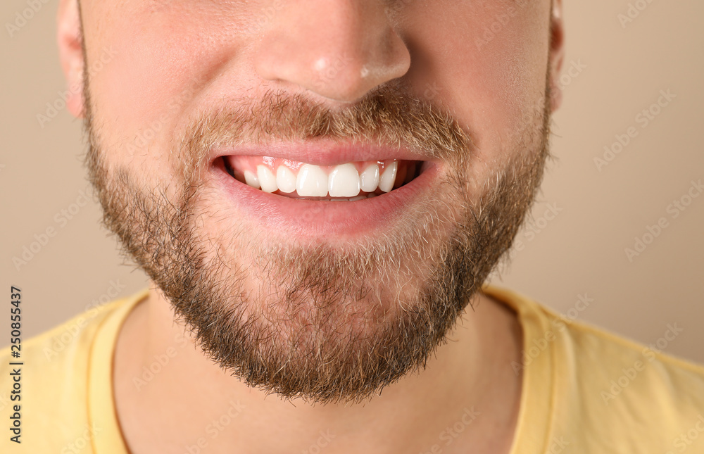 Obraz premium Young man with healthy teeth on color background, closeup