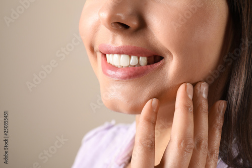 Young woman with healthy teeth on color background  closeup