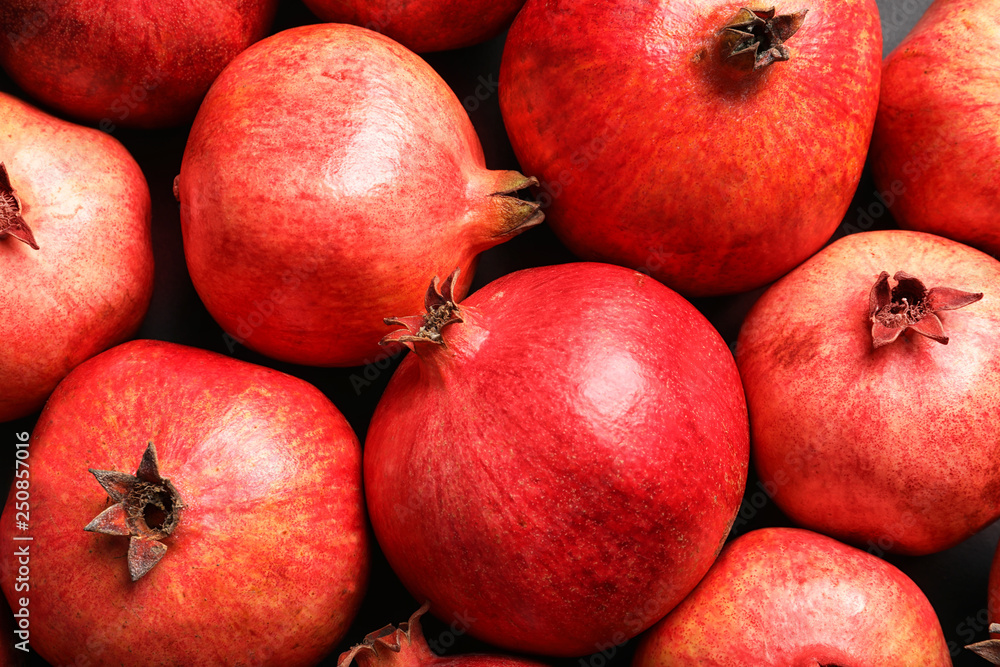 Ripe red pomegranates on grey background, top view Ripe red pomegranates on grey background, top view