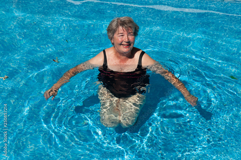 Senior woman smiling in a pool