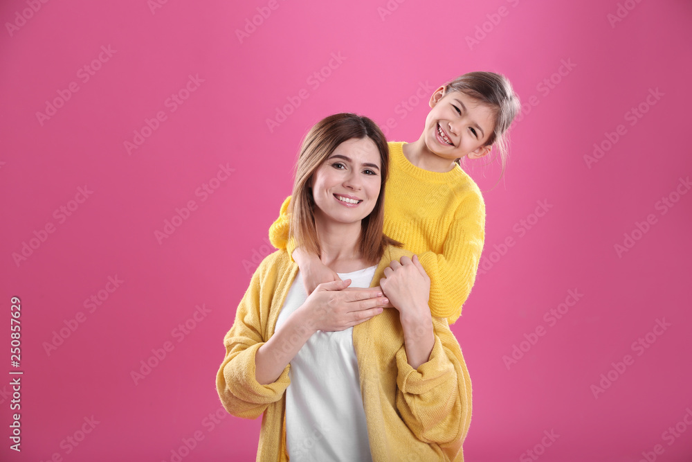 Happy woman and daughter in stylish clothes on color background Happy woman and daughter in stylish clothes on color background