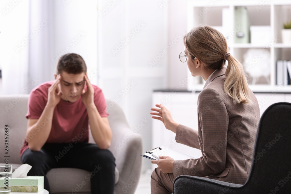 Psychotherapist working with young man in office Psychotherapist working with young man in office