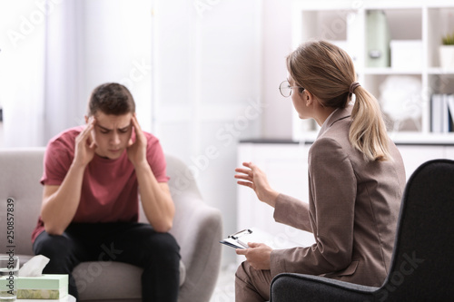 Psychotherapist working with young man in office