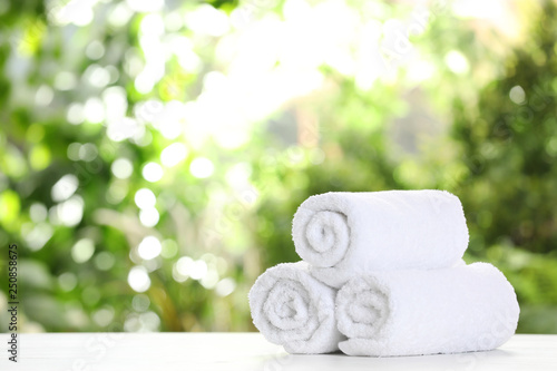 Soft bath towels on table against blurred background. Space for text