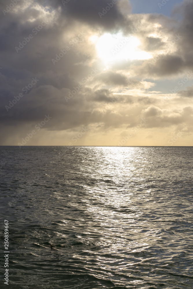 夕日に照らされる雲と海
