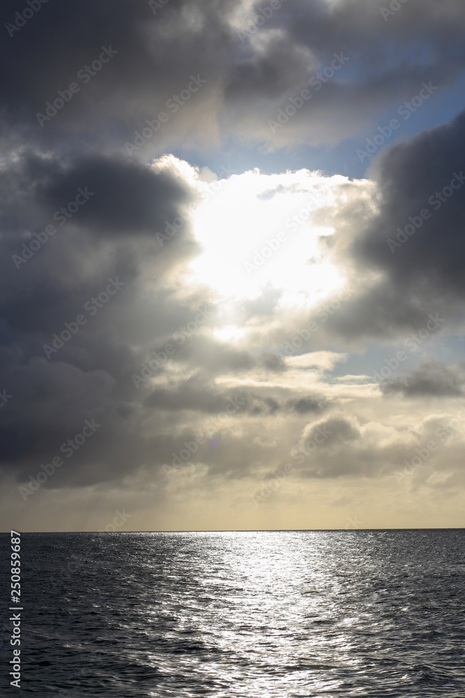 太陽に照らされる雲と海