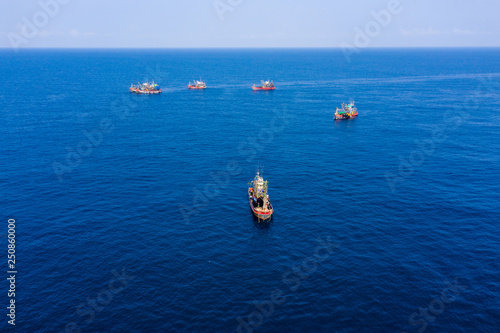 Overfishing - aerial view of a large fleet of fishing trawlers working together in a small area of the Andaman Sea