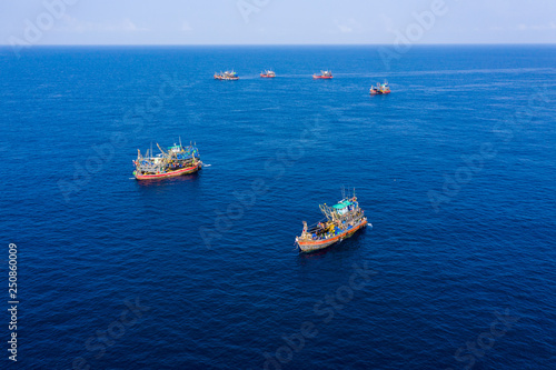 Unsustainable overfishing - aerial view of a fleet of large fishing trawlers operating togather in the Black Rock island in the Mergui Archipelago, Myanmar