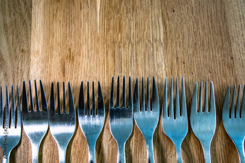 Many Forks in a row on a wooden table