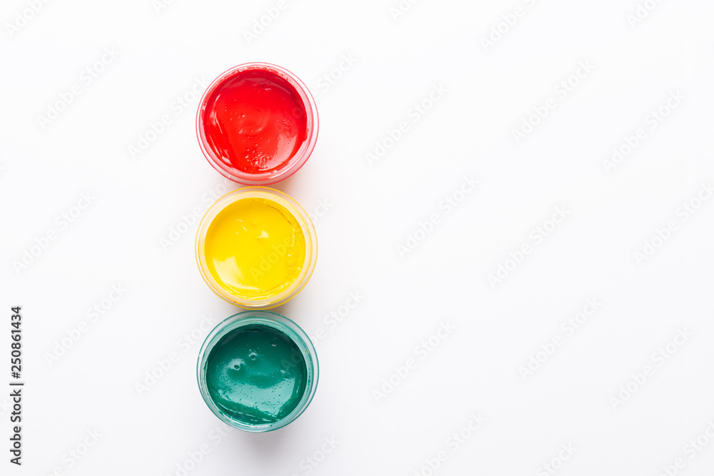 Red, yellow, green gouache on a white background Isolated Paints in containers Top view Traffic light