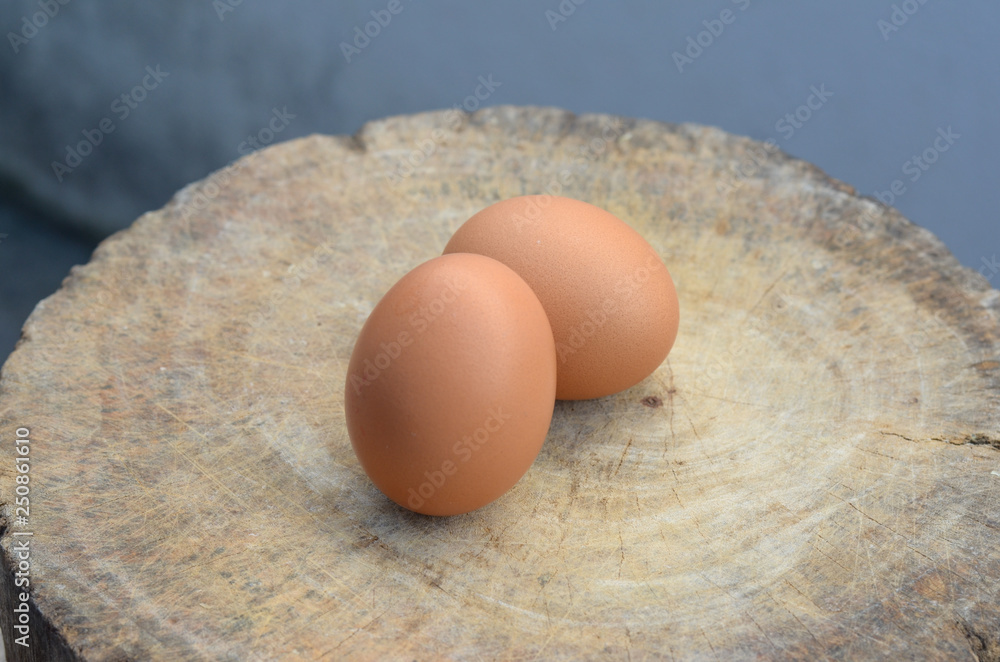 Two eggs placed on a wooden cutting board Two eggs placed on a wooden cutting board